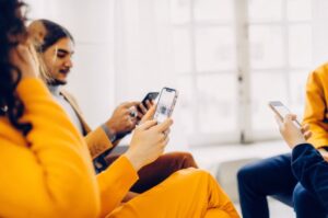 A group of people using Instagram on smartphones in a bright office.