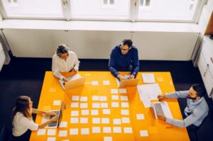 Ομάδα επαγγελματιών της TWO DOTS σε δημιουργική συνάντηση brainstorming για UX design.