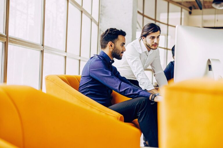 Έλληνες επιχειρηματίες και επαγγελματίες digital marketing σε ένα σύγχρονο γραφείο, κοιτάζουν έναν υπολογιστή