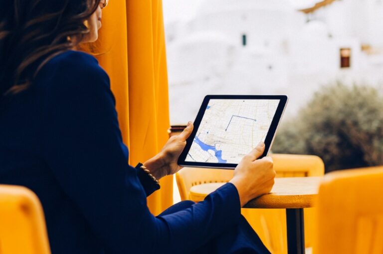 Επιχειρηματίας στην Ελλάδα εξετάζει καταχωρήσεις και στατιστικά στοιχεία σε ηλεκτρονικό χάρτη σε tablet