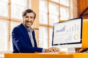 Επιχειρηματίας μπροστά από υπολογιστή με εργαλεία τεχνητής νοημοσύνης