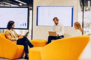 Team of professionals working on campaign using AI tools for TWO DOTS PR in modern office