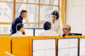 Ομάδα επαγγελματιών εξετάζει αναλυτικά δεδομένα SEO σε υπολογιστές με χρήση τεχνητής νοημοσύνης