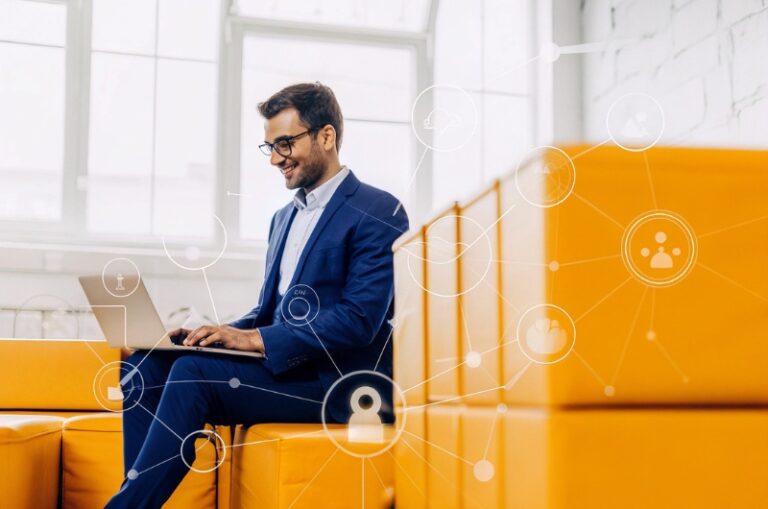 Νεαρός επιχειρηματίας σε σύγχρονο γραφείο χρησιμοποιεί laptop με εικονίδια τεχνητής νοημοσύνης, απεικονίζοντας τον ανταγωνισμό στις μηχανές αναζήτησης