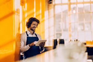 Ιδιοκτήτης καφετέριας που ελέγχει τα στατιστικά στο Google Business Profile με τη βοήθεια της TWO DOTS για καλύτερη τοπική κατάταξη