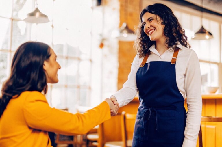Μία επαγγελματίας χαιρετά εγκάρδια έναν πιστό πελάτη, δείχνοντας τη σημαντικότητα της αφοσίωσης στην πρόοδο και την ανάπτυξη της