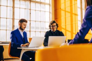 TWO DOTS' modern entrepreneurs work together on AI voice agent solutions in an office, highlighting the advantages of AI voice assistants