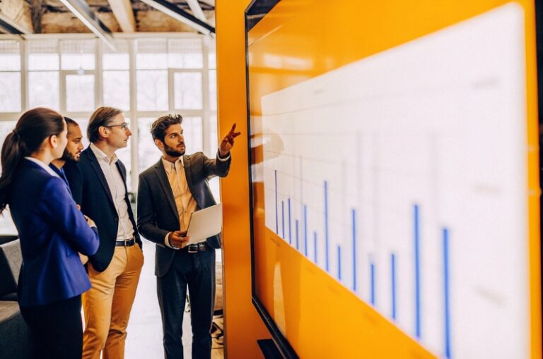 Επαγγελματίες της TWO DOTS εξετάζουν λέξεις-κλειδιά ανταγωνιστών σε σύγχρονο γραφείο, κάνοντας ανάλυση ανταγωνισμού για στρατηγική SEO