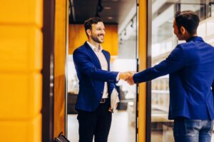 Предприемач от TWO DOTS разменя ръкостискане с клиент, илюстрирайки създаването на суперфенове чрез подобряване на преживяването на клиентите