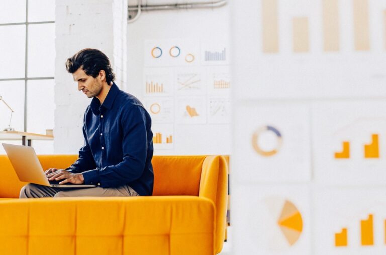 Млад предприемач използва инструменти за цифров маркетинг в офиса си, представяйки марката TWO DOTS