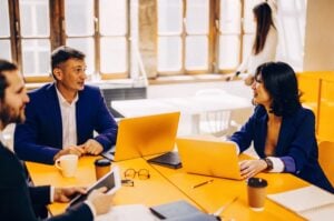 Επιχειρηματίες συζητούν στρατηγικές για landing page σε γραφείο, προβάλλοντας τη σημασία των σελίδων προσγείωσης για την TWO DOTS