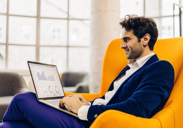 Επιχειρηματίας που κάθετε με το laptop του και εργάζεται πάνω σε σύστημα μηχανογράφισης που παρείχε η TWO DOTS