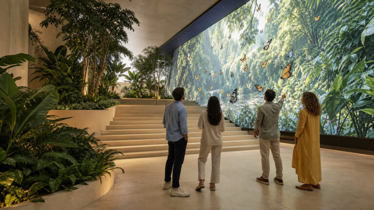 Επισκέπτες σε immersive retail εμπειρία με ψηφιακές πεταλούδες και εσωτερικό κήπο